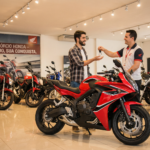 Jovem recebendo chave de moto nova em concessionária após contemplação no consórcio de moto